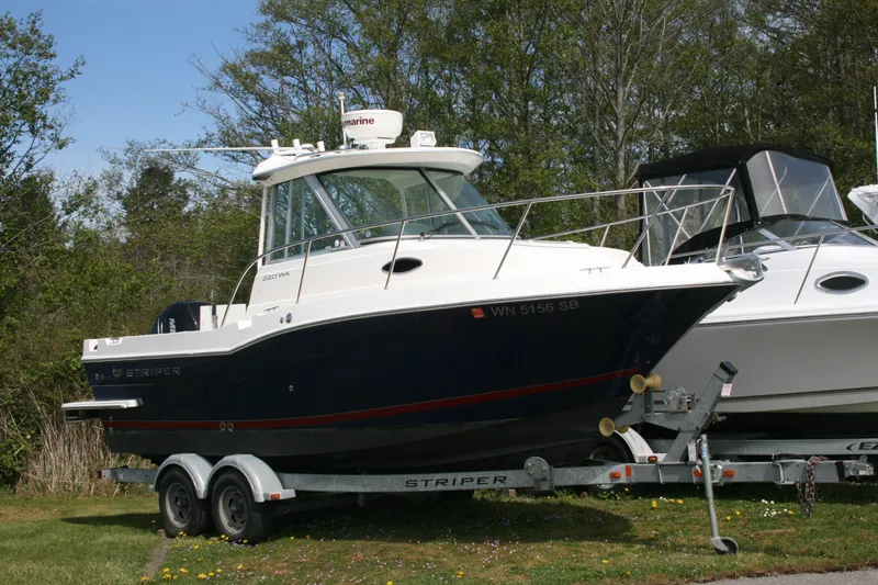 Slide: The Image of 2014 Seaswirl Striper 220 WA boat on trailer, parked outdoors. - 2