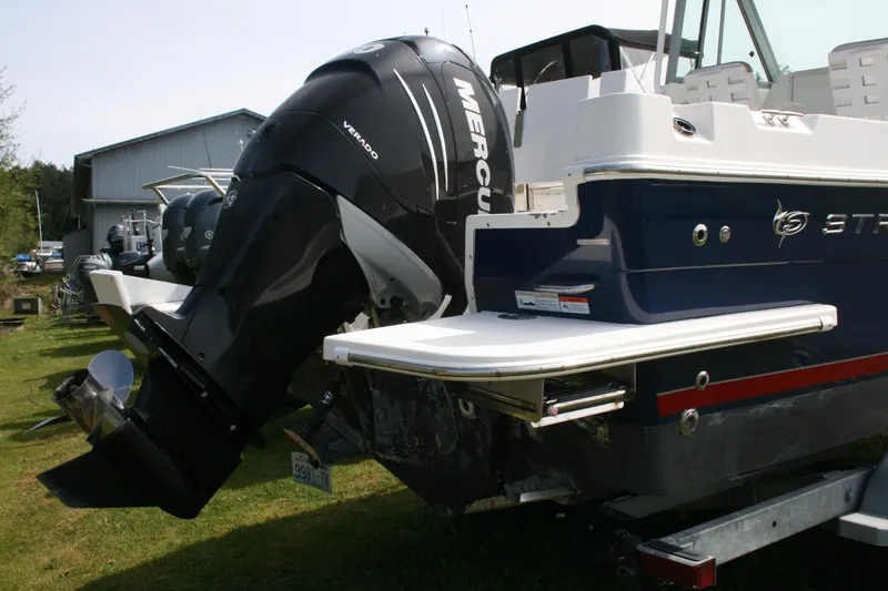 Slide: The Image of 2014 Seaswirl Striper 220 WA boat with Mercury Verado outboard motor, parked on grass. - 23