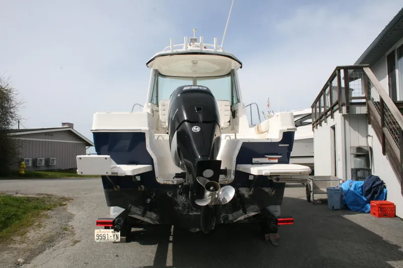 Slide: The Image of 2014 Seaswirl Striper 220 WA boat with outboard motor, parked on a trailer. - 24