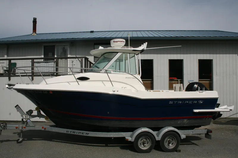 Slide: The Image of 2014 Seaswirl Striper 220 WA boat on trailer, parked near a building. - 3