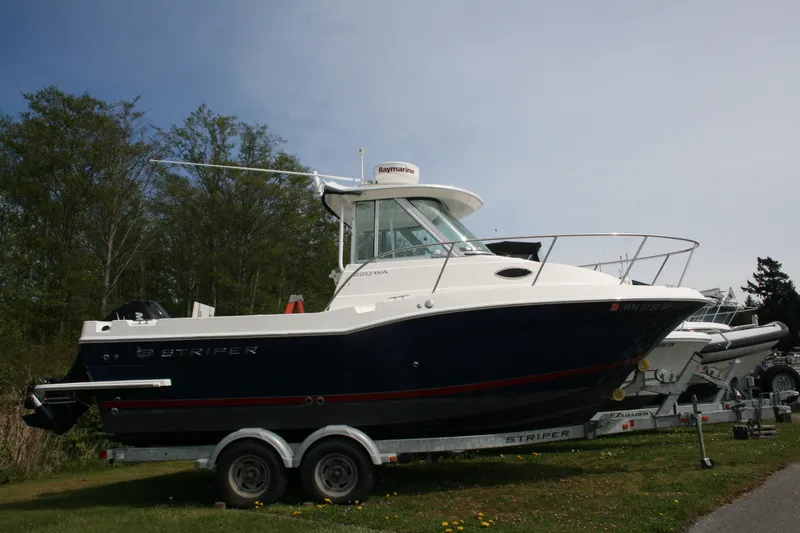 Slide: The Image of 2014 Seaswirl Striper 220 WA boat on trailer, parked outdoors with trees in background. - 4