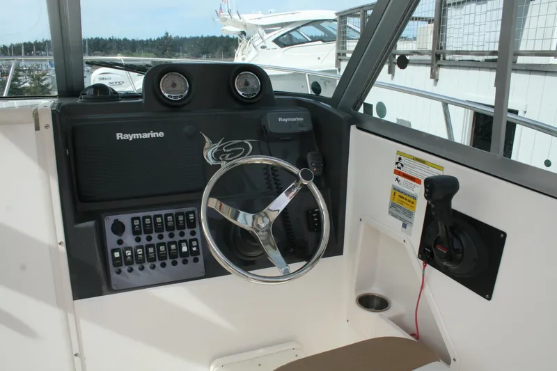 Slide: The Image of 2014 Seaswirl Striper 220 WA boat dashboard with Raymarine electronics and steering wheel. - 6