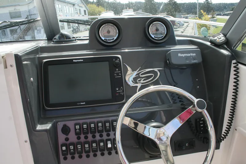 Slide: The Image of 2014 Seaswirl Striper 220 WA boat dashboard with Raymarine electronics and steering wheel. - 8