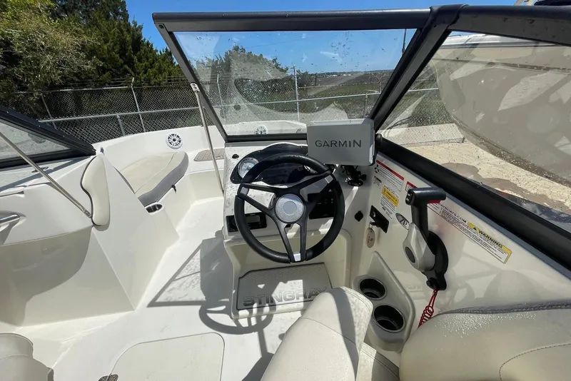 Slide: The Image of 2023 Stingray 191 DC boat interior with Garmin navigation system and steering wheel. - 10