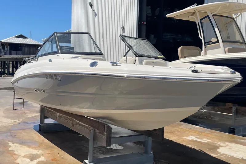 Slide: The Image of 2023 Stingray 191 DC boat displayed outdoors on a stand. - 2