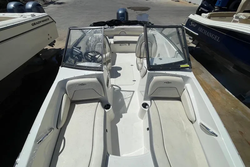 Slide: The Image of 2023 Stingray 191 DC boat interior with seating and windshield, docked beside other boats. - 6