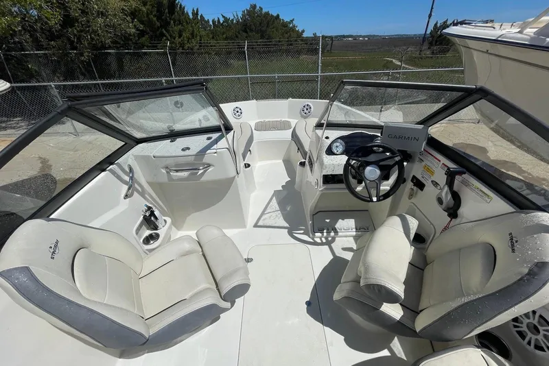 Slide: The Image of 2023 Stingray 191 DC boat interior with steering wheel and seating. - 9
