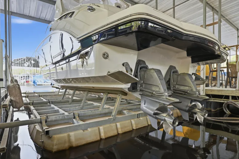 Slide: The Image of 2014 Chaparral 327 SSX boat in dry dock, showcasing dual propellers and sleek design. - 12