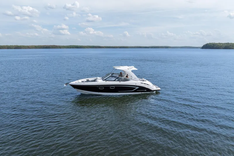 Slide: The Image of 2014 Chaparral 327 SSX boat cruising on a calm lake under a partly cloudy sky. - 5
