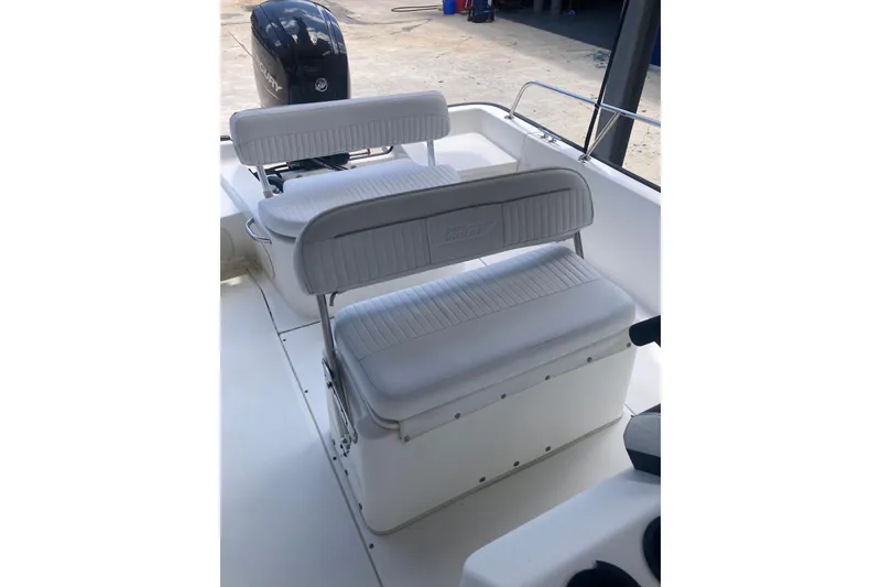 Slide: The Image of 2007 Boston Whaler 190 Montauk boat interior with white seating and Mercury engine. - 12