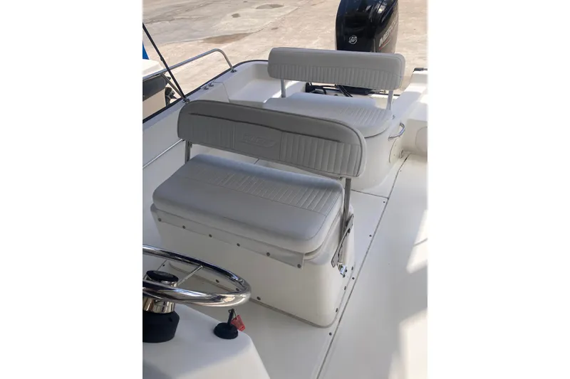 Slide: The Image of 2007 Boston Whaler 190 Montauk boat interior with cushioned seating and steering wheel. - 13