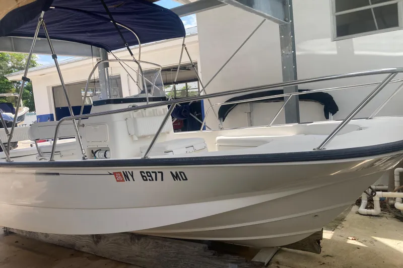 Slide: The Image of 2007 Boston Whaler 190 Montauk boat with canopy, docked in a marina. - 19