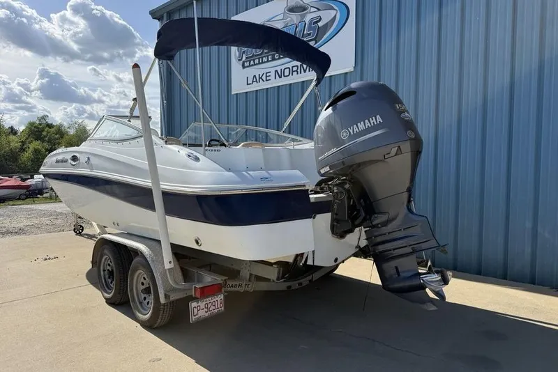 The Image of 2014 SouthWind 212sd boat with Yamaha engine on trailer, parked outside a marine shop. - 1