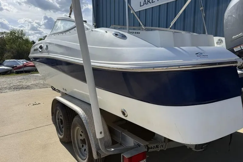 Slide: The Image of 2014 SouthWind 212sd boat on trailer, parked outdoors near a blue building. - 10