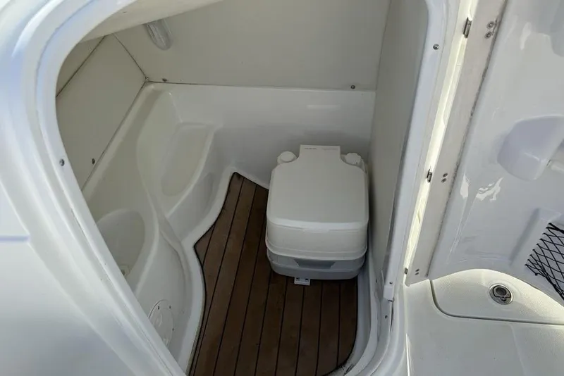 Slide: The Image of 2014 SouthWind 212sd boat interior with compact marine toilet and wooden flooring. - 36