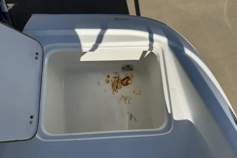 Slide: The Image of Open storage compartment on a 2014 SouthWind 212sd boat with rust stains inside. - 45