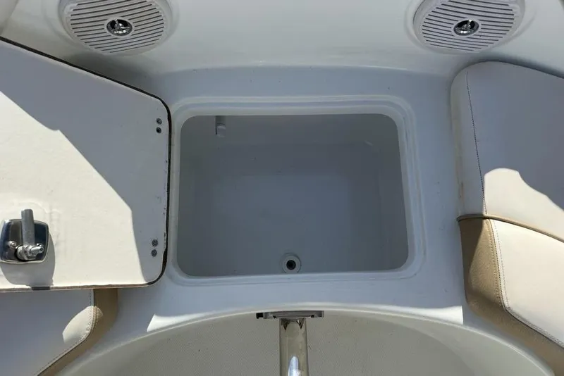 Slide: The Image of Open storage compartment on a 2014 SouthWind 212sd boat, featuring beige seating and speakers. - 47