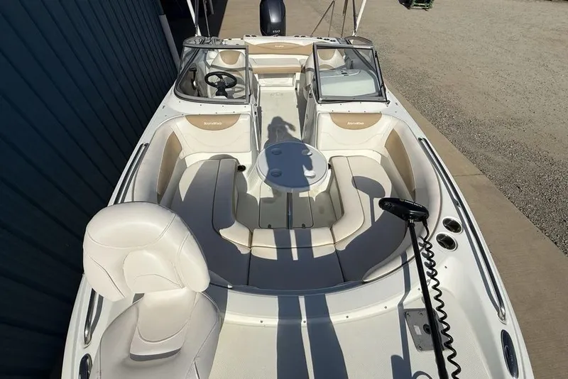 Slide: The Image of 2014 SouthWind 212sd boat interior with seating and steering wheel, docked outdoors. - 48