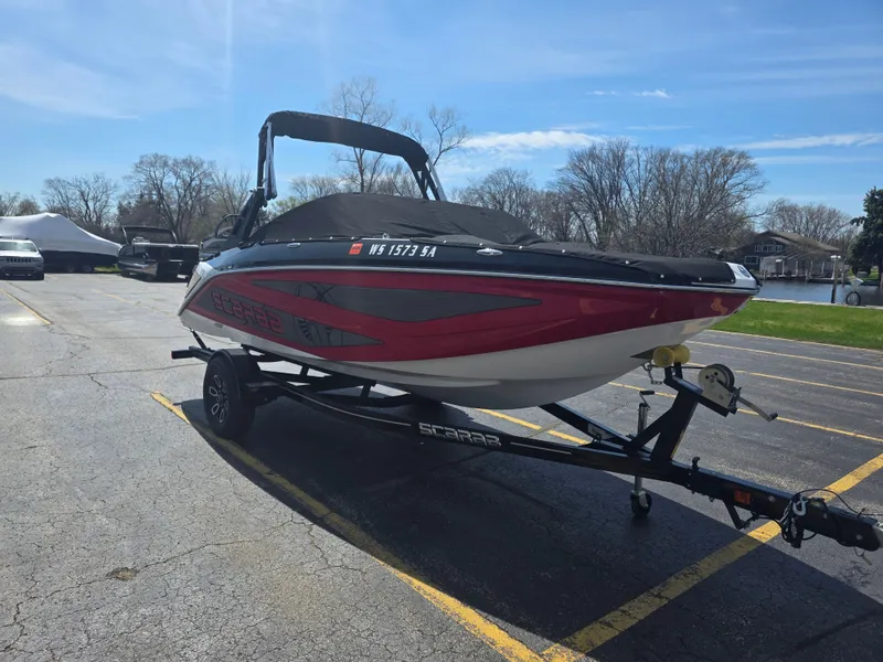 Slide: The Image of 2023 Scarab 195 ID Impact boat parked on trailer outdoors. - 2