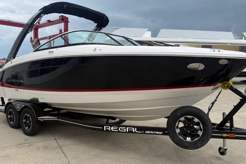 The Image of 2019 Regal LS4 boat on trailer, black and white design, parked outdoors. - 1