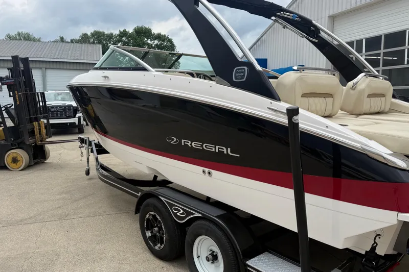 Slide: The Image of 2019 Regal LS4 boat on trailer, black and white with red stripe, parked outdoors. - 4