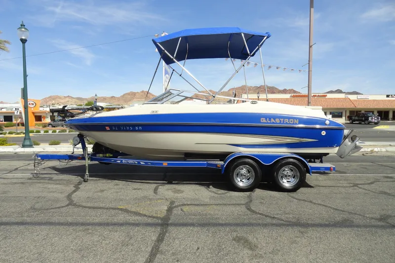 The Image of 2004 Glastron GX 205 Ski & Fish boat with blue and white design on trailer. - 1