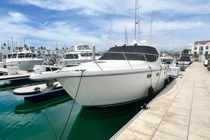 Slide: The Image of 2008 Tiara Yachts 3500 Sovran docked at a marina under a clear blue sky. - 2