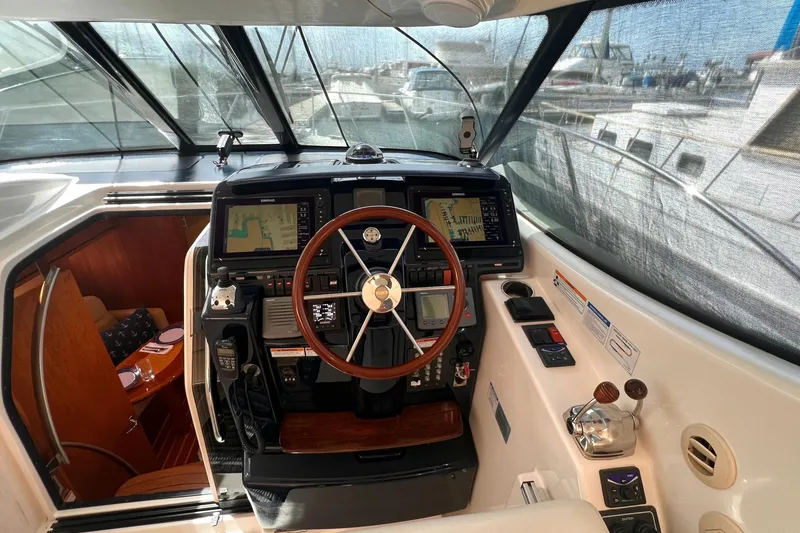 Slide: The Image of 2008 Tiara Yachts 3500 Sovran helm with navigation screens and wooden steering wheel. - 21