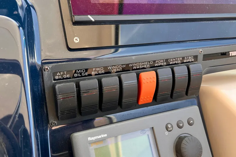 Slide: The Image of Control panel of a 2008 Tiara Yachts 3500 Sovran with labeled switches and Raymarine display. - 28