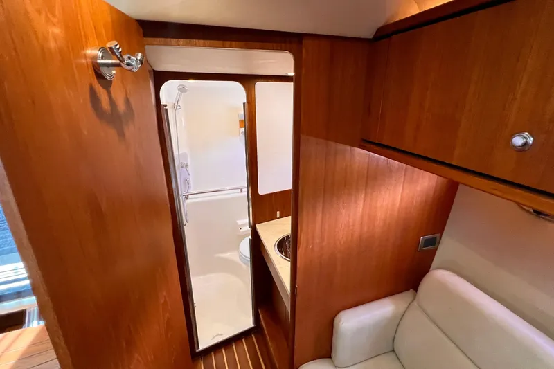 Slide: The Image of Interior of 2008 Tiara Yachts 3500 Sovran, featuring wooden cabinetry and a compact bathroom. - 47