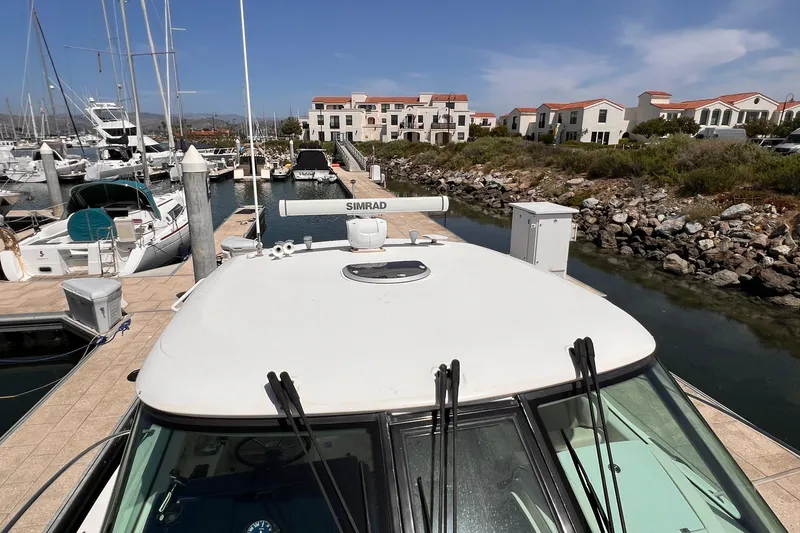 Slide: The Image of 2008 Tiara Yachts 3500 Sovran docked at a marina with waterfront buildings. - 5