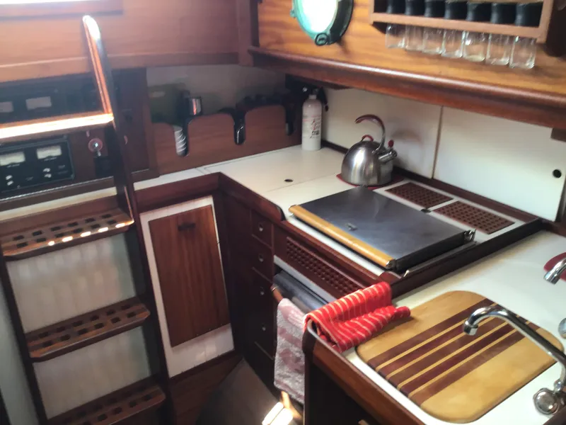 Slide: The Image of Interior of a 2006 Bristol Channel Cutter 28, featuring kitchen and wood paneling. - 22