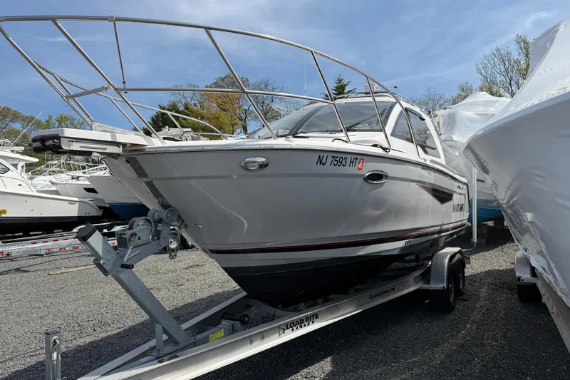 Slide: The Image of 2024 Solara S-250 Coupe boat on trailer, parked outdoors under clear sky. - 4
