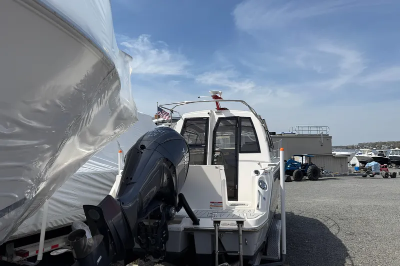 Slide: The Image of 2024 Solara S-250 Coupe boat with outboard motor in a marina setting. - 6