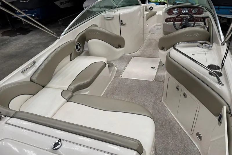 Slide: The Image of 2007 Sea Ray 240 Sundeck interior with beige seating and dashboard view. - 11