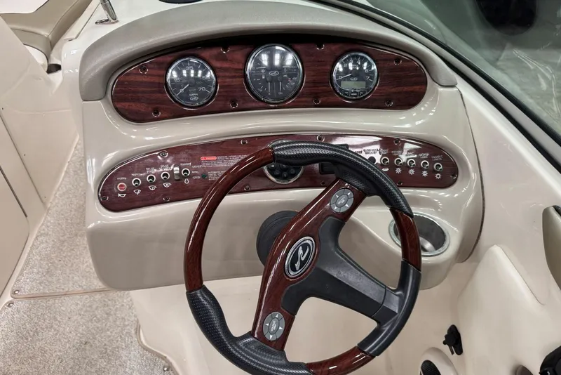 Slide: The Image of 2007 Sea Ray 240 Sundeck dashboard with wood accents and steering wheel. - 16