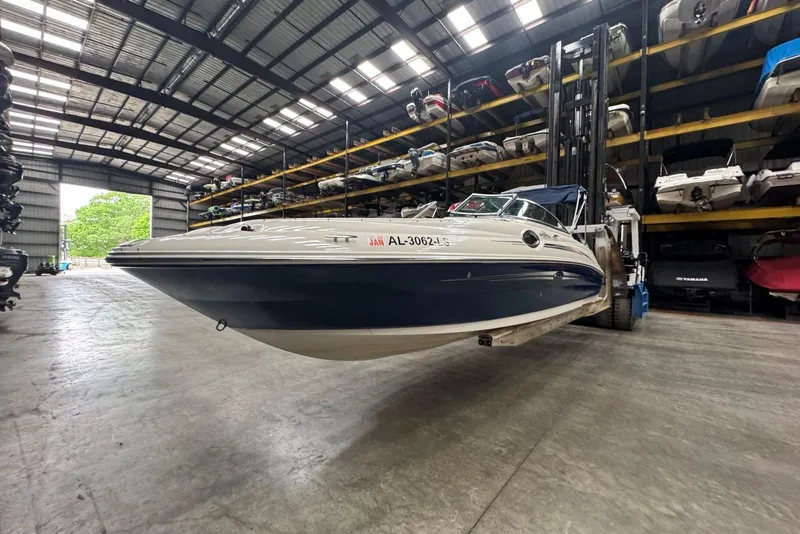 Slide: The Image of 2007 Sea Ray 240 Sundeck boat in storage facility, elevated by forklift. - 2