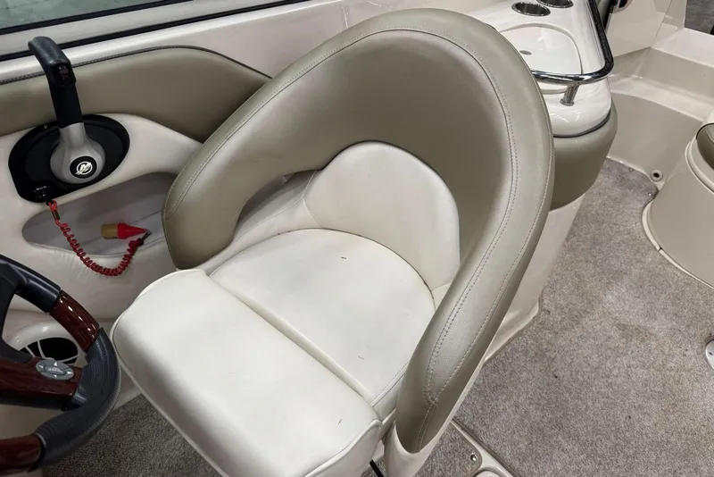 Slide: The Image of 2007 Sea Ray 240 Sundeck interior with beige seating and steering wheel detail. - 20