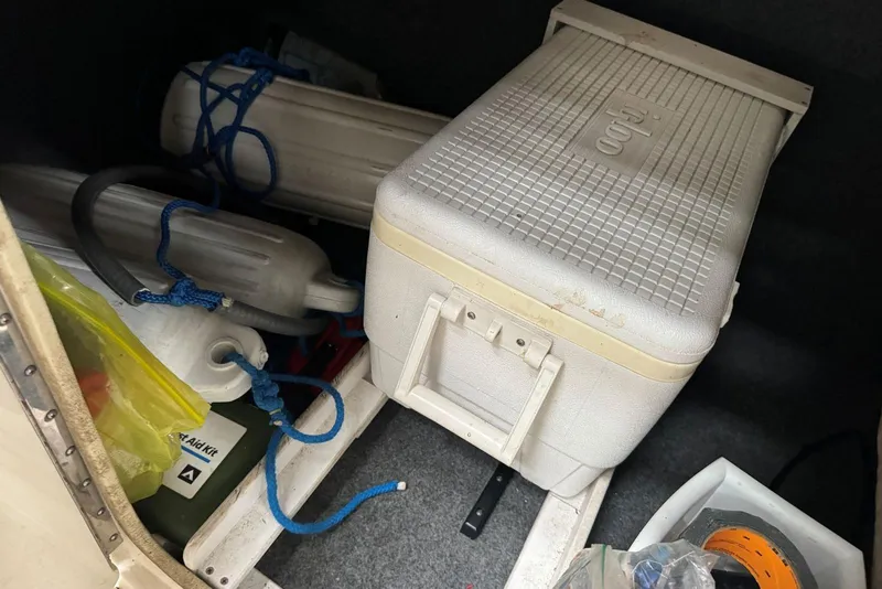 Slide: The Image of Storage compartment of a 2007 Sea Ray 240 Sundeck with cooler and boat accessories. - 26