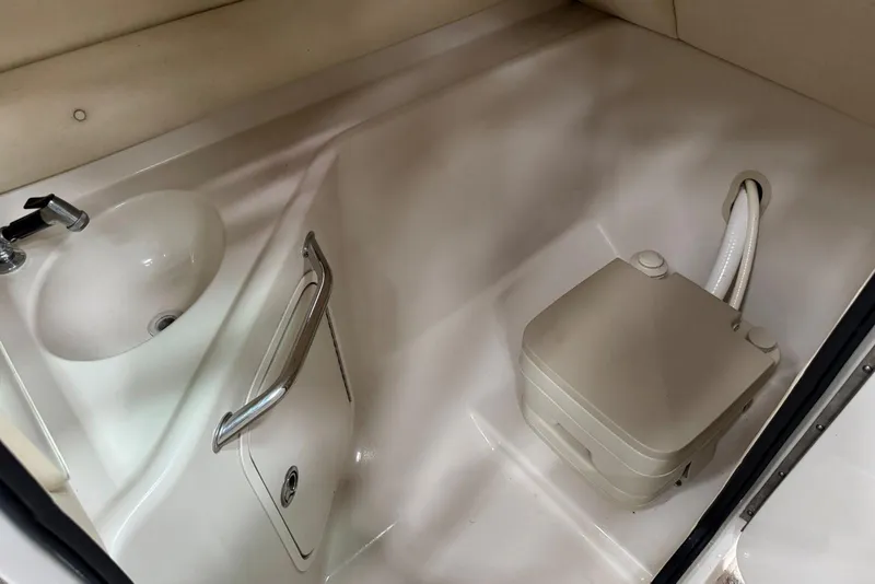 Slide: The Image of 2007 Sea Ray 240 Sundeck interior with sink and portable toilet. - 33