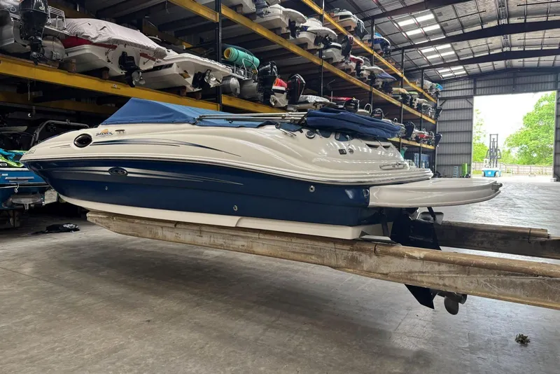 Slide: The Image of 2007 Sea Ray 240 Sundeck boat in storage, featuring blue and white design. - 37