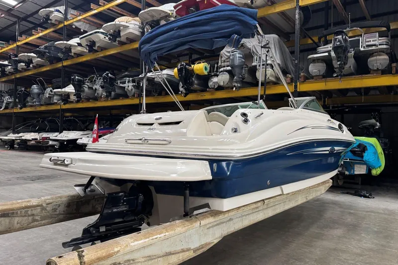 Slide: The Image of 2007 Sea Ray 240 Sundeck boat in indoor storage, surrounded by other vessels. - 4