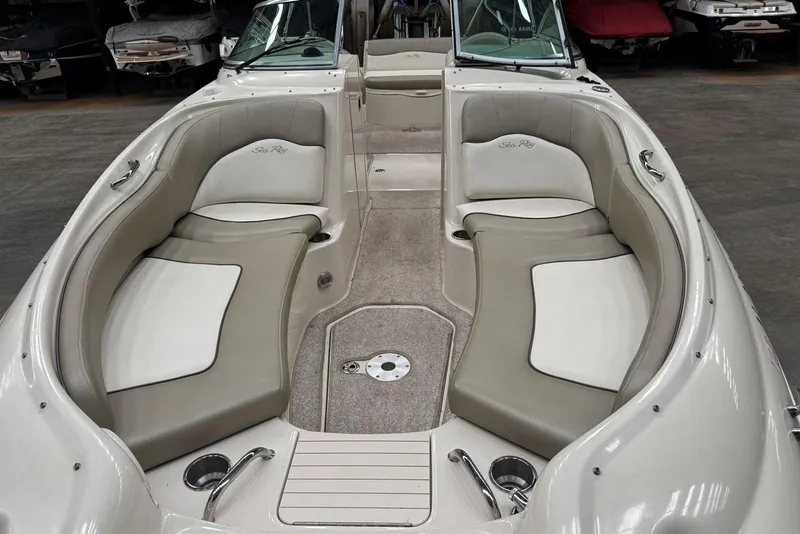 Slide: The Image of 2007 Sea Ray 240 Sundeck interior with beige seating and cup holders. - 9