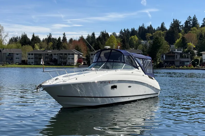 The Image of 2010 Sea Ray Sundancer 280 boat on a serene lake with houses and trees in the background. - 0