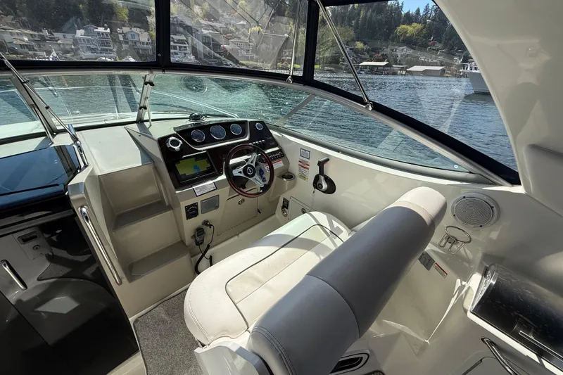 Slide: The Image of Interior view of 2010 Sea Ray Sundancer 280 boat cockpit with steering wheel and controls. - 24