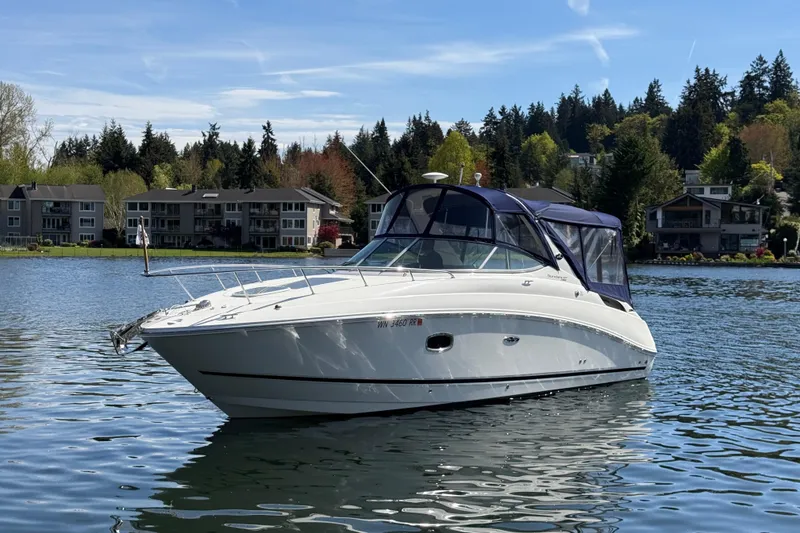 Slide: The Image of 2010 Sea Ray Sundancer 280 boat on a serene lake with houses and trees in the background. - 3