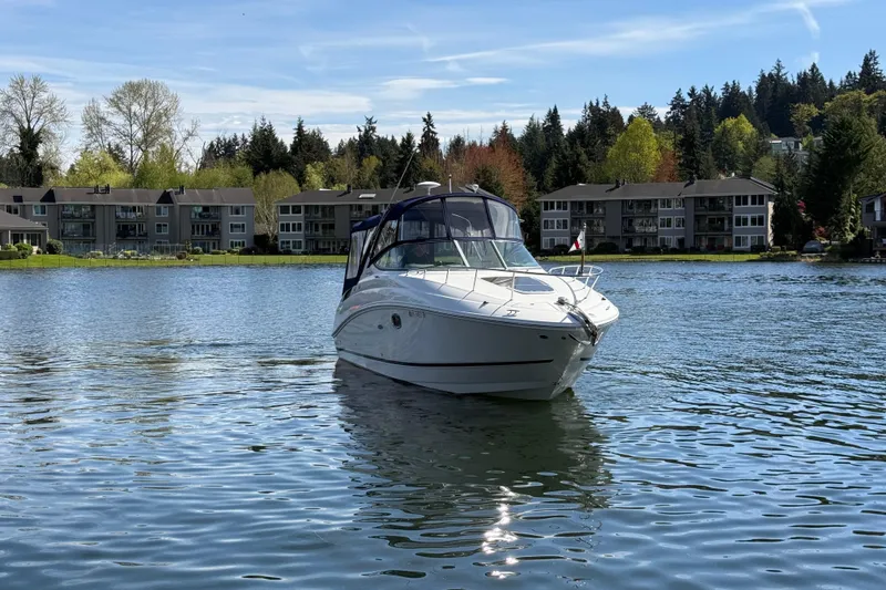 Slide: The Image of 2010 Sea Ray Sundancer 280 boat on a serene lake with houses in the background. - 4