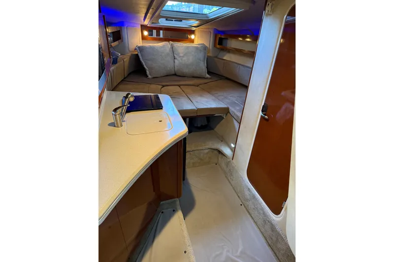 Slide: The Image of Interior of 2010 Sea Ray Sundancer 280, featuring cozy cabin with bed and kitchenette. - 6