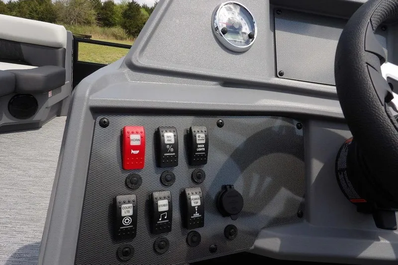 Slide: The Image of Control panel of 2026 Sylvan R-22 LZ DH boat with switches and steering wheel. - 22