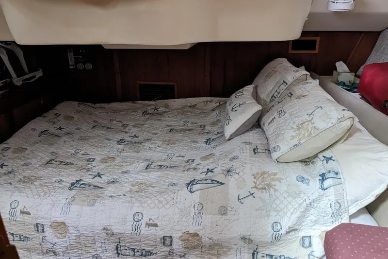 Slide: The Image of Cozy cabin bed in a 2002 Hunter 410 sailboat with nautical-themed bedding. - 11